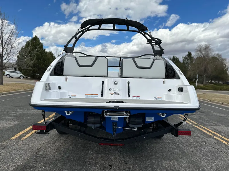 Slide: The Image of 2025 Yamaha AR250 boat on trailer, rear view, parked on road under cloudy sky. - 3