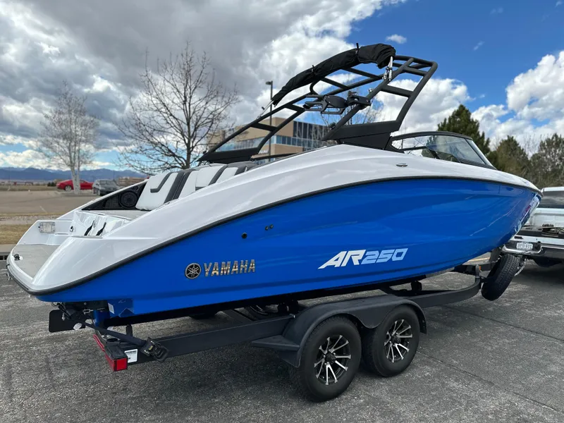 Slide: The Image of 2025 Yamaha Boats AR250 on trailer, blue and white design, parked outdoors under cloudy sky. - 4