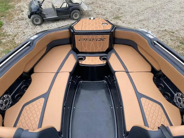 Slide: The Image of 2025 Yamaha Boats 255XD interior with tan and black seating, cup holders, and speakers. - 11