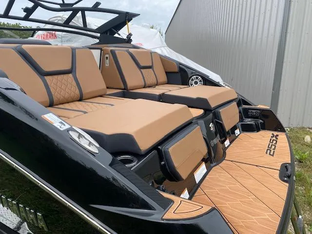 Slide: The Image of 2025 Yamaha Boats 255XD with luxurious tan seating and sleek black exterior design. - 2