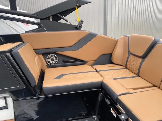 Slide: The Image of 2025 Yamaha Boats 255XD interior with tan and black seating, featuring a built-in speaker. - 6