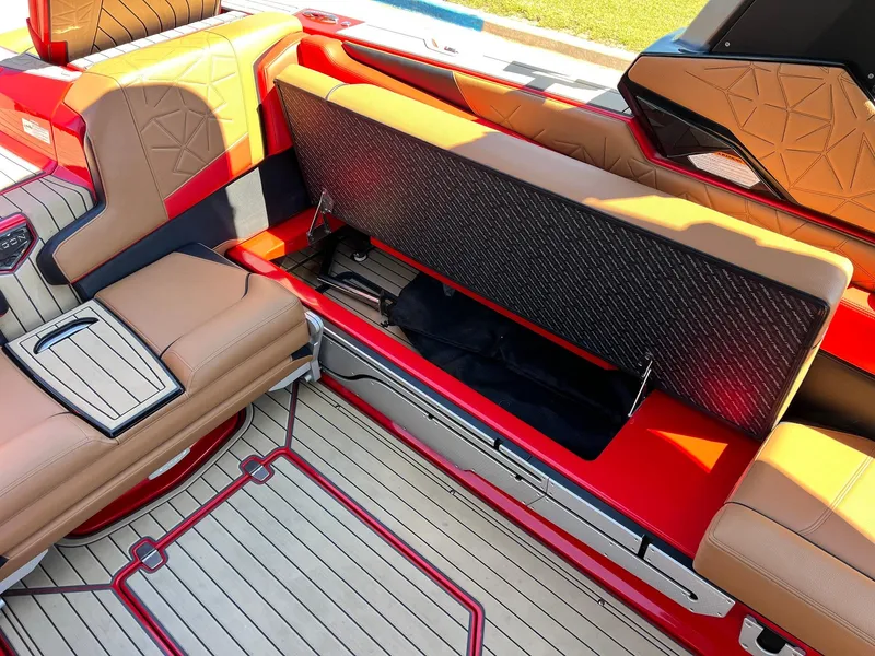 Slide: The Image of 2021 Nautique Super Air Nautique G25 Paragon interior with open storage compartment, red and tan seating. - 31