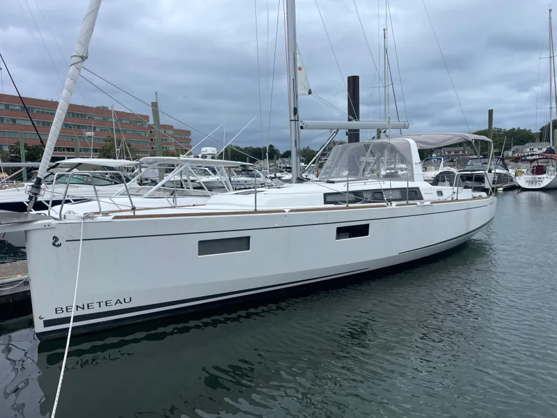 Slide: The Image of 2022 Beneteau Oceanis 38.1 sailboat docked in a marina, overcast sky. - 11