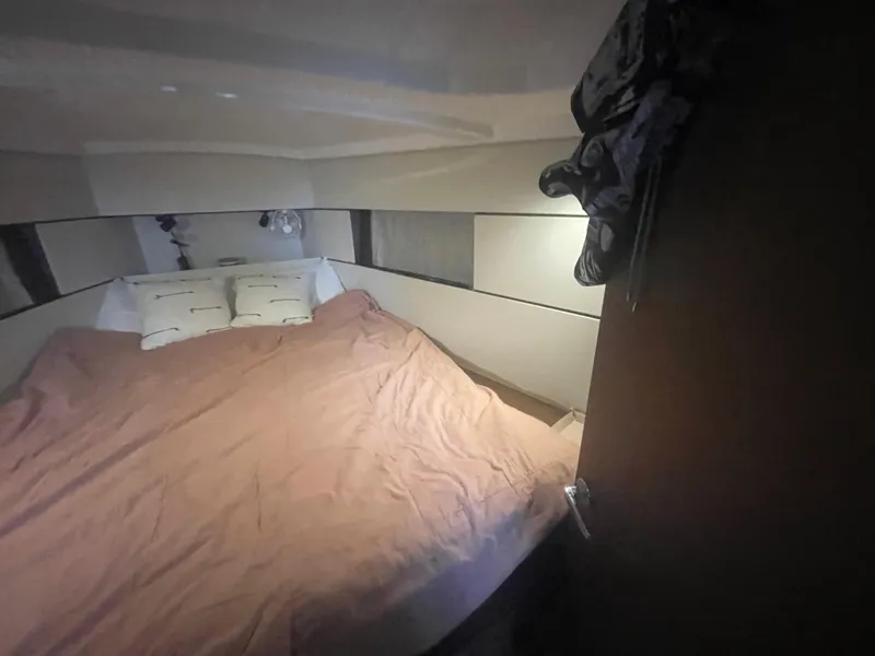 Slide: The Image of Cozy cabin interior of 2022 Beneteau Oceanis 38.1 sailboat with bed and pillows. - 22