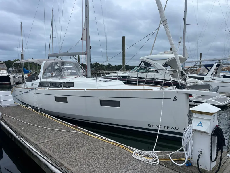 Slide: The Image of 2022 Beneteau Oceanis 38.1 sailboat docked at marina under cloudy skies. - 26