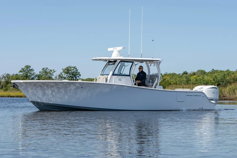 The Image of 2025 Sportsman Open 322 Center Console boat on calm water, side view. - 1