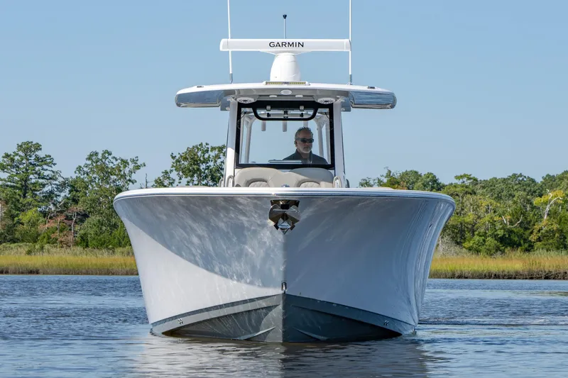 Slide: The Image of 2025 Sportsman Open 322 Center Console boat on calm water, front view. - 4