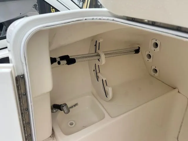 Slide: The Image of Key West 239 DFS 2020 boat storage compartment with rod holders and sink. - 7