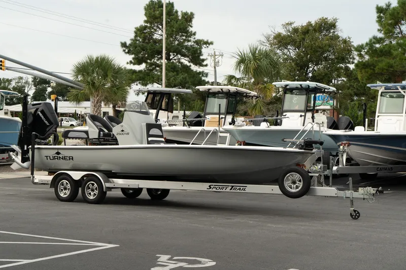 The Image of 2025 Turner Boatworks 2500 VS on trailer in parking lot, surrounded by other boats. - 0