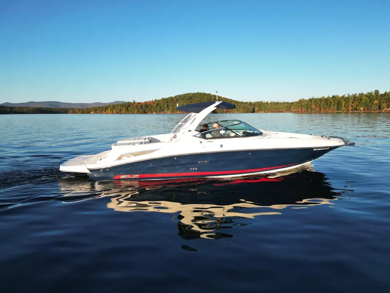 The Image of 2015 Sea Ray 300 SLX boat cruising on a serene lake under clear blue skies. - 0