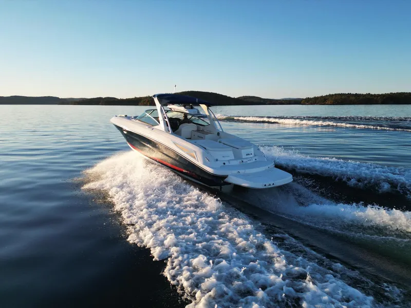 Slide: The Image of 2015 Sea Ray 300 SLX cruising on a serene lake at sunset. - 13