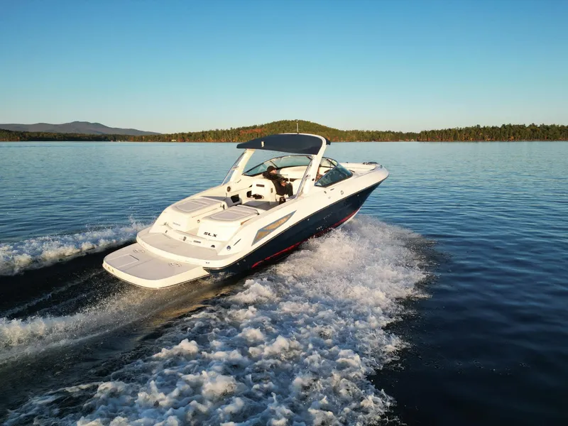 Slide: The Image of 2015 Sea Ray 300 SLX cruising on a serene lake at sunset. - 18