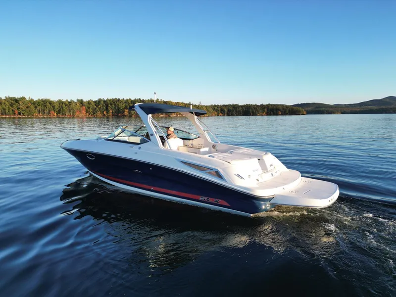 Slide: The Image of 2015 Sea Ray 300 SLX cruising on a serene lake under a clear blue sky. - 5