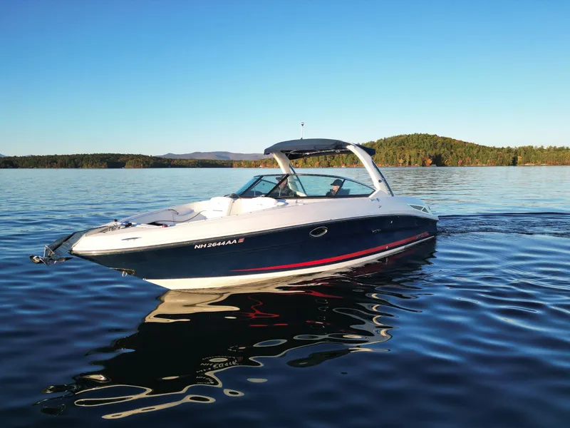 Slide: The Image of 2015 Sea Ray 300 SLX boat cruising on a serene lake under clear blue skies. - 6