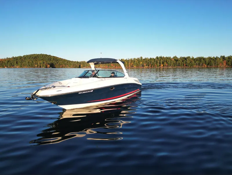 Slide: The Image of 2015 Sea Ray 300 SLX boat on a serene lake with forested shoreline. - 8