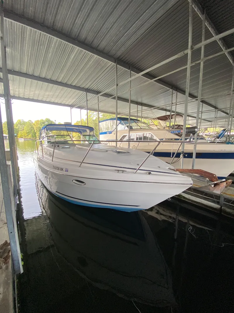 The Image of 2000 Rinker 340 Fiesta Vee boat docked under a covered marina. - 0