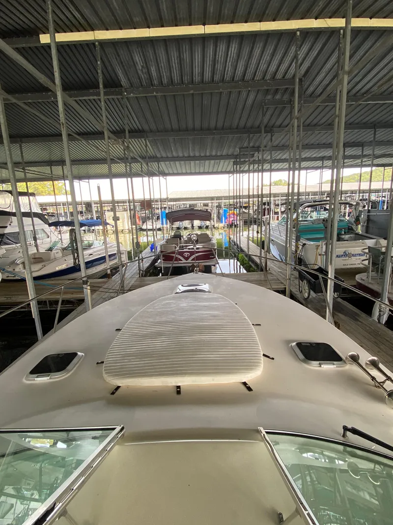 Slide: The Image of 2000 Rinker 340 Fiesta Vee docked in a covered marina. - 12