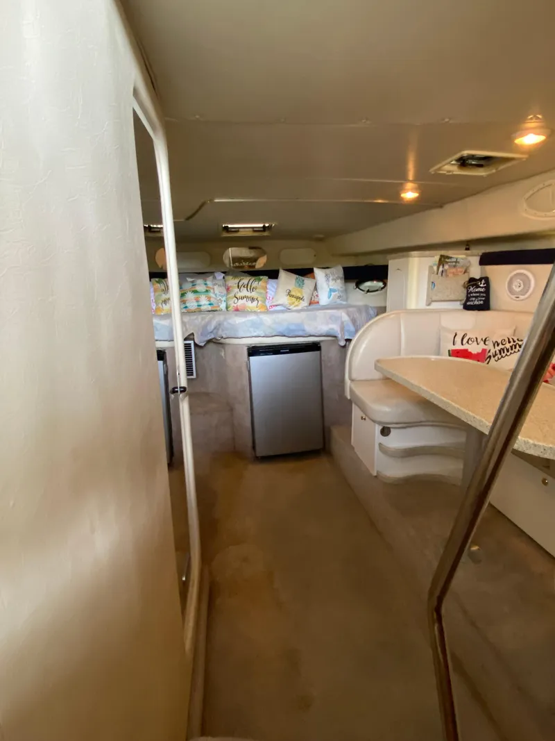 Slide: The Image of Interior of 2000 Rinker 340 Fiesta Vee boat with cozy seating and mini fridge. - 14