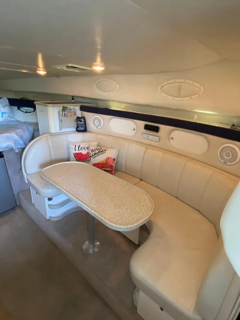 Slide: The Image of Interior of 2000 Rinker 340 Fiesta Vee boat with cozy seating and table. - 15