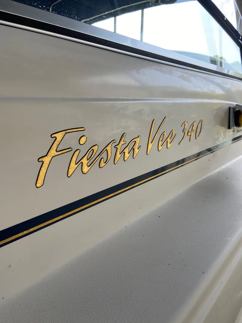 Slide: The Image of 2000 Rinker 340 Fiesta Vee boat nameplate with gold lettering. - 2