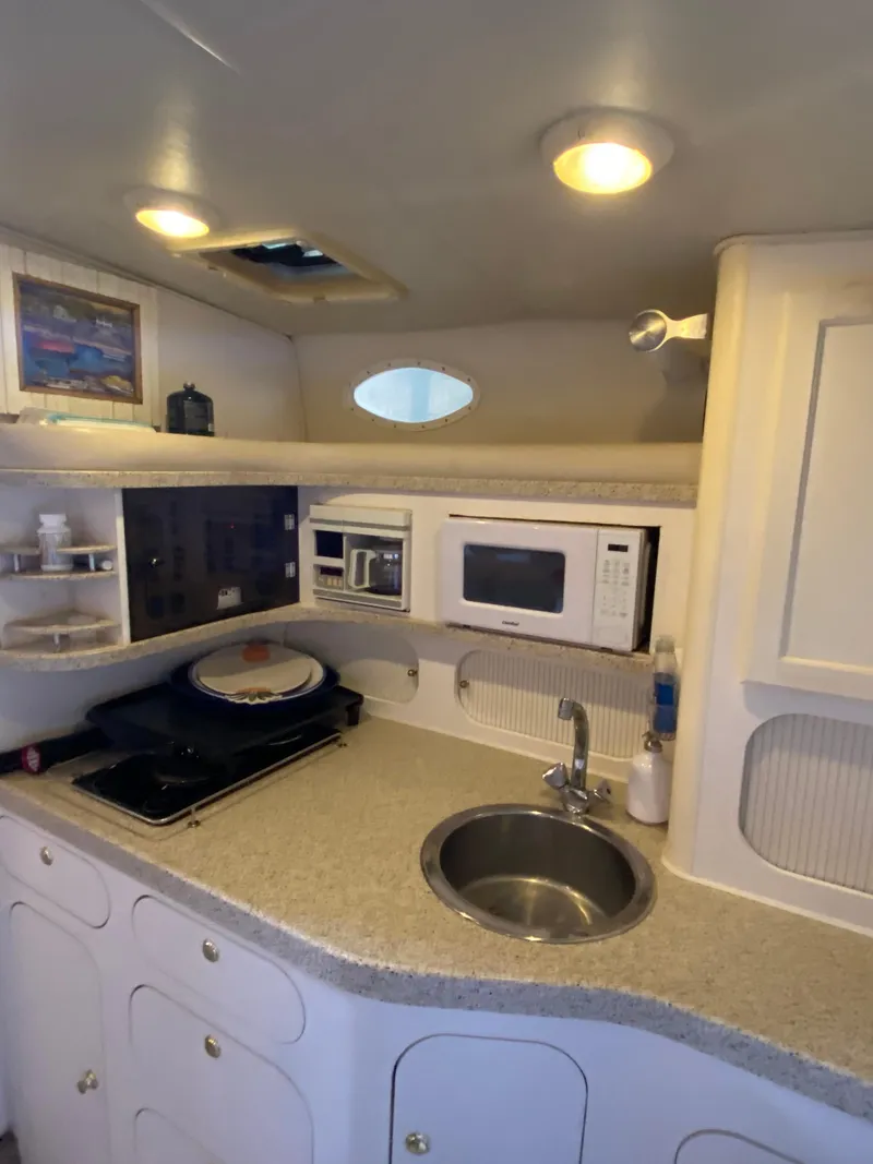 Slide: The Image of 2000 Rinker 340 Fiesta Vee yacht kitchen with sink, microwave, and stove. - 20