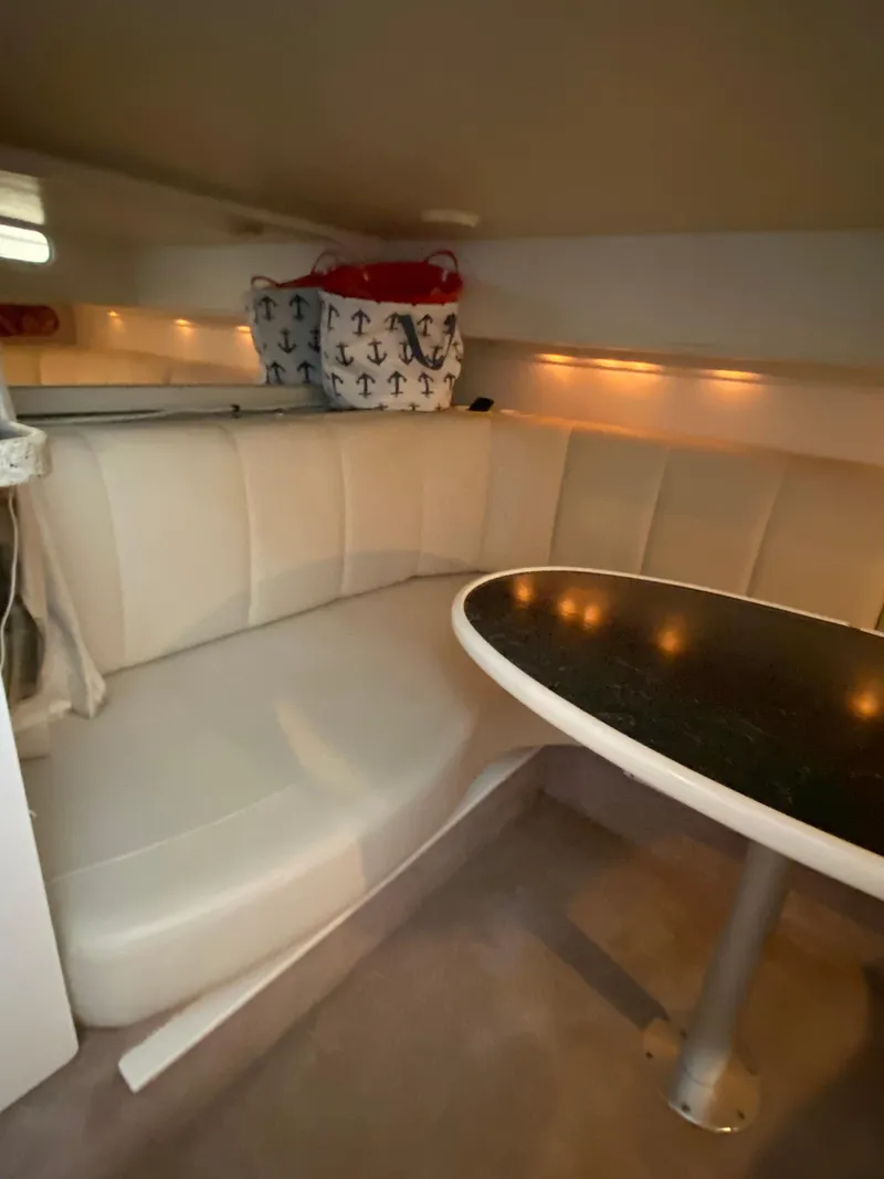 Slide: The Image of Interior of 2000 Rinker 340 Fiesta Vee with white seating and a round table. - 21