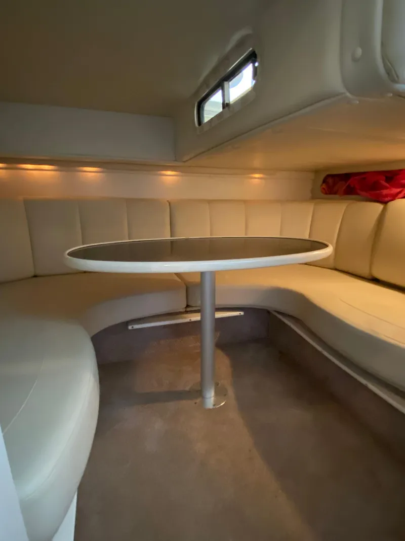 Slide: The Image of 2000 Rinker 340 Fiesta Vee cabin interior with round table and cushioned seating. - 22