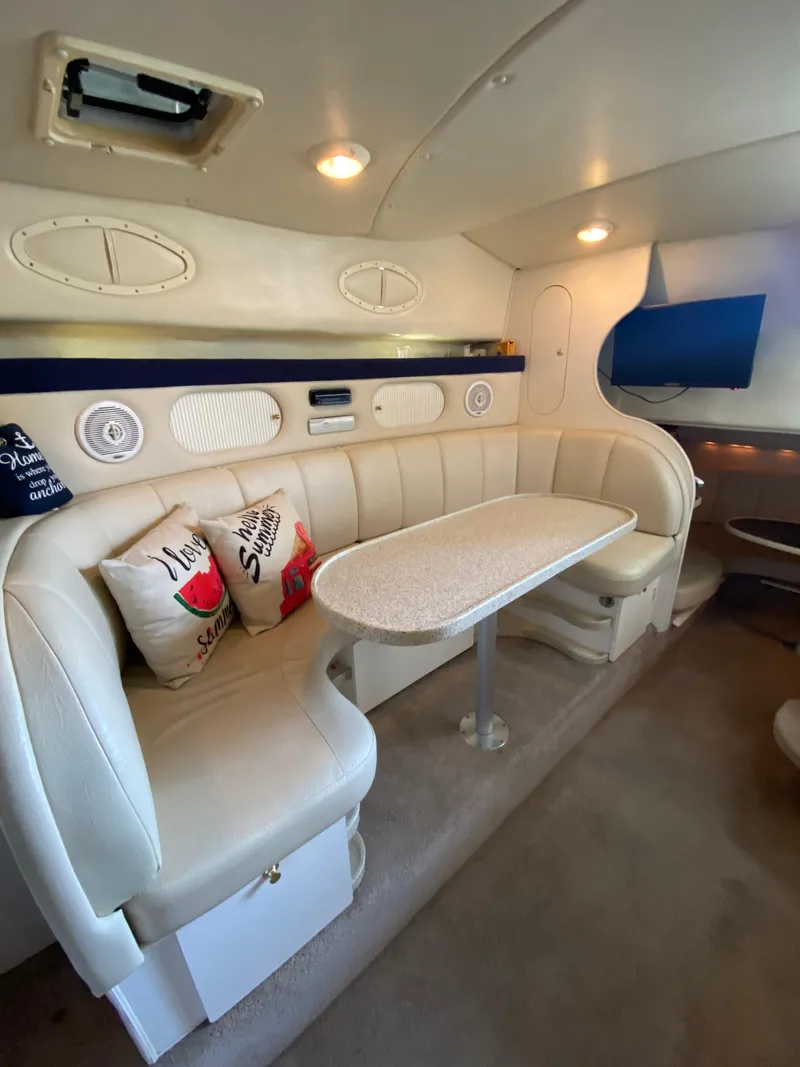 Slide: The Image of Interior of 2000 Rinker 340 Fiesta Vee boat with cozy seating and table. - 24