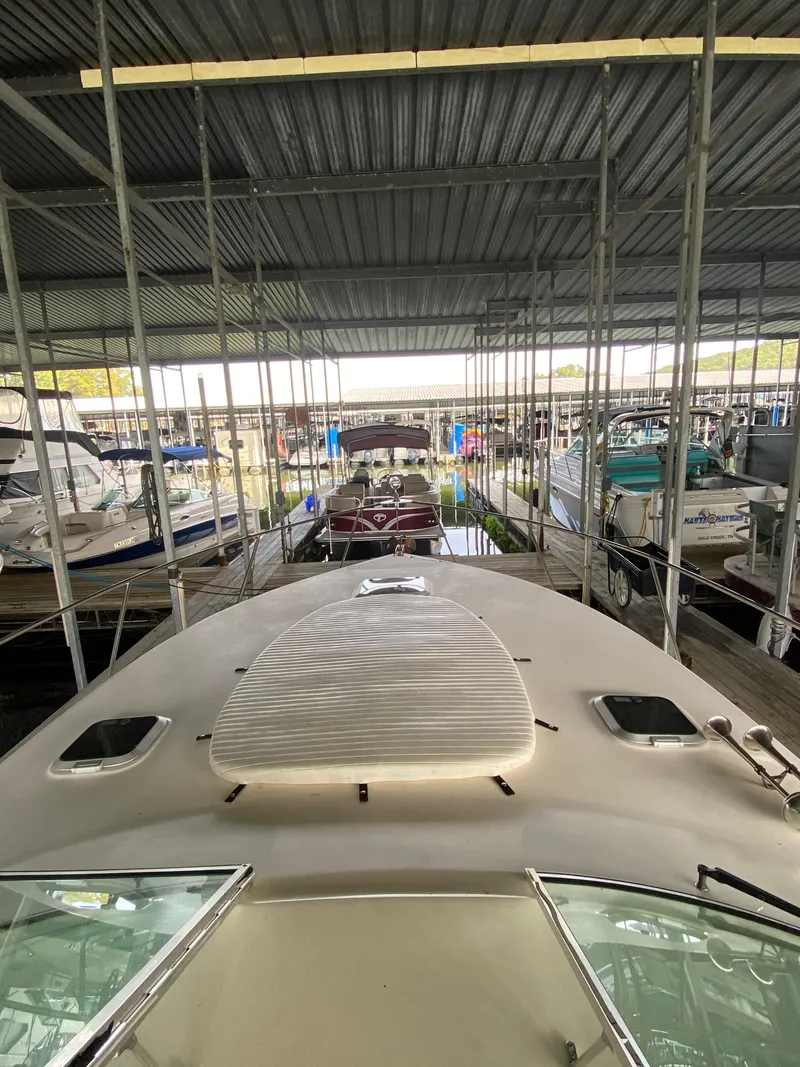 Slide: The Image of 2000 Rinker 340 Fiesta Vee docked in a covered marina. - 14