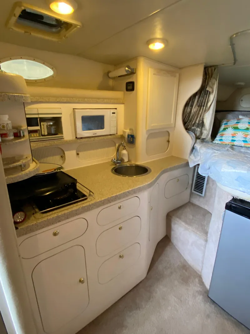 Slide: The Image of 2000 Rinker 340 Fiesta Vee boat interior with kitchenette and cozy sleeping area. - 17