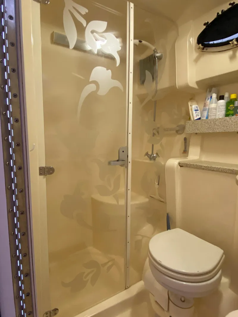 Slide: The Image of 2000 Rinker 340 Fiesta Vee bathroom with shower, toilet, and toiletries on shelf. - 20