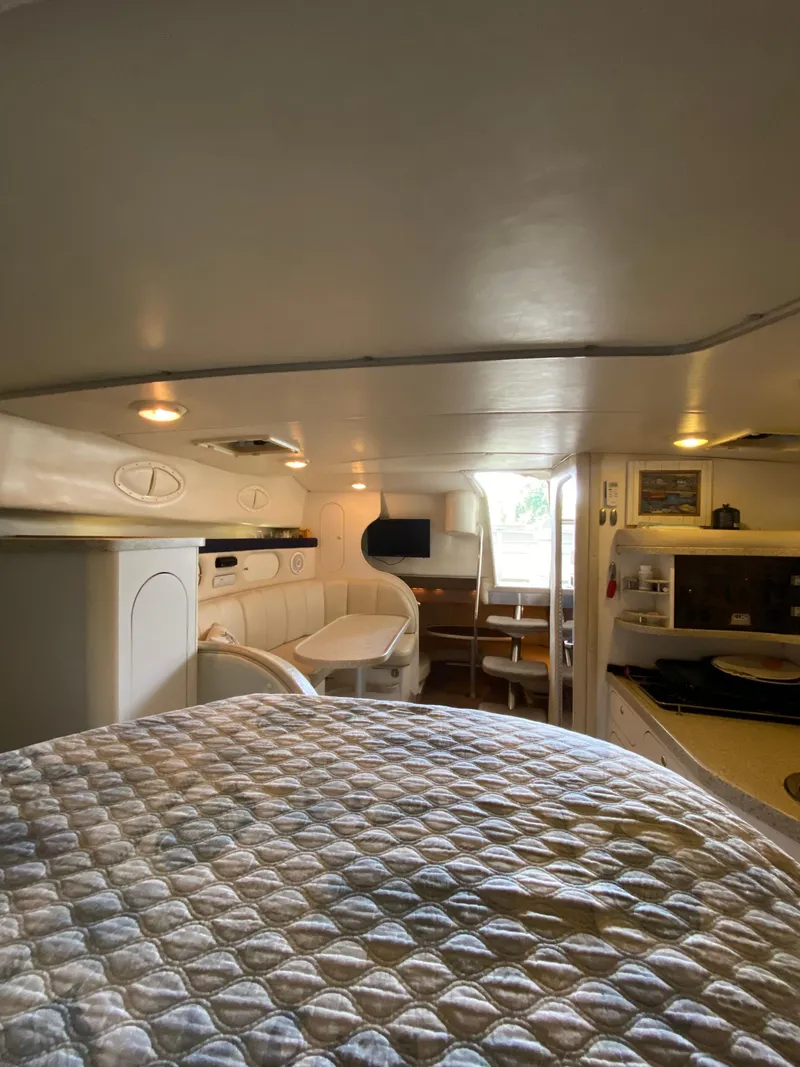 Slide: The Image of Interior of 2000 Rinker 340 Fiesta Vee boat, featuring cozy cabin and dining area. - 26