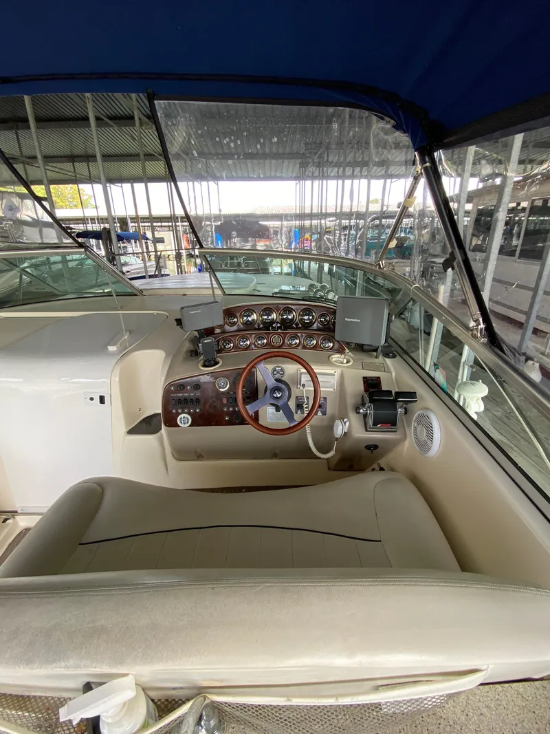 Slide: The Image of 2000 Rinker 340 Fiesta Vee boat cockpit with steering wheel and control panel. - 9
