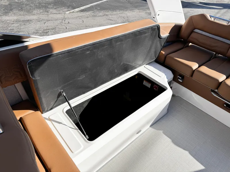 Slide: The Image of 2025 Regal LS6 boat interior with open storage compartment and brown seating. - 15