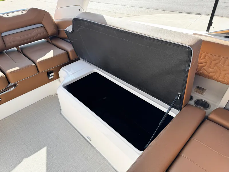 Slide: The Image of 2025 Regal LS6 boat interior with open storage compartment and brown seating. - 18