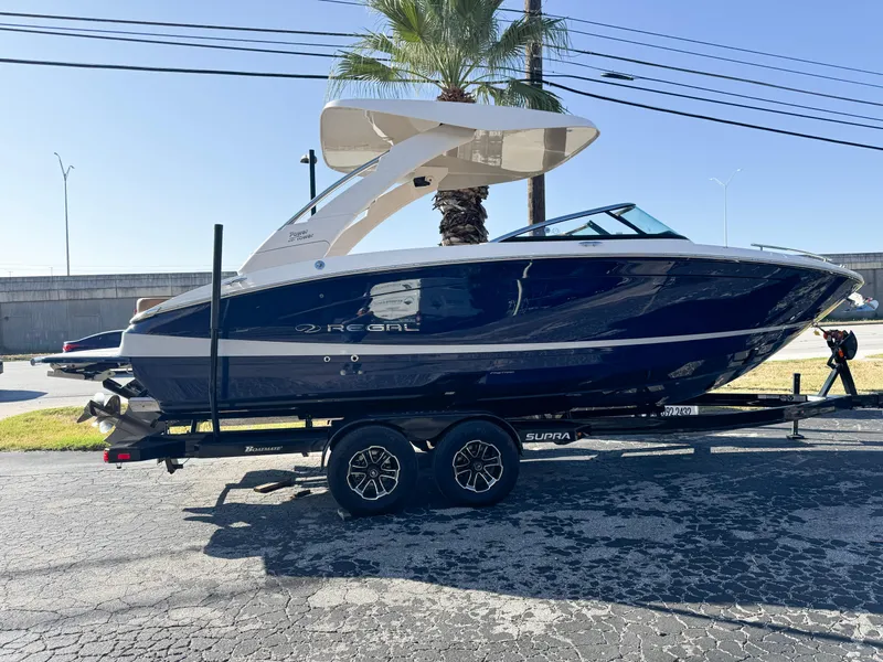 Slide: The Image of 2025 Regal LS6 boat on trailer, parked outdoors under clear sky. - 2