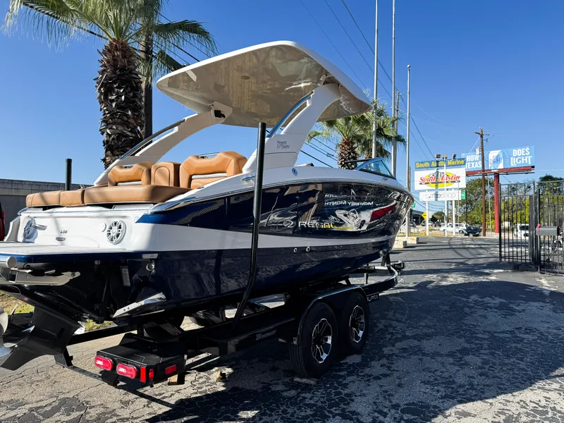 Slide: The Image of 2025 Regal LS6 boat on trailer, parked outdoors under palm trees. - 3