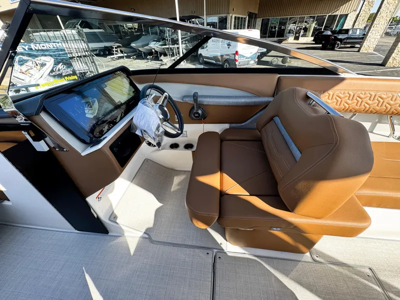 Slide: The Image of 2025 Regal LS6 boat interior with brown leather seating and modern dashboard. - 33