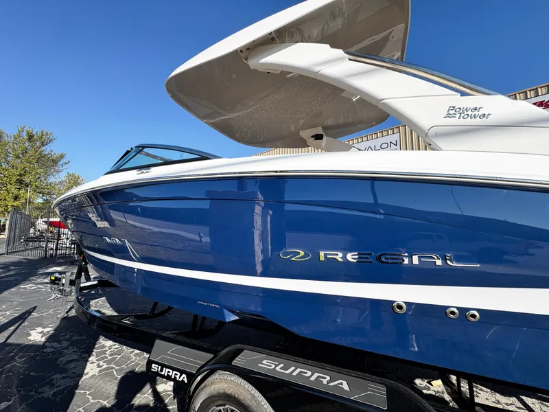 Slide: The Image of 2025 Regal LS6 boat in blue on a Supra trailer, sunny day. - 7