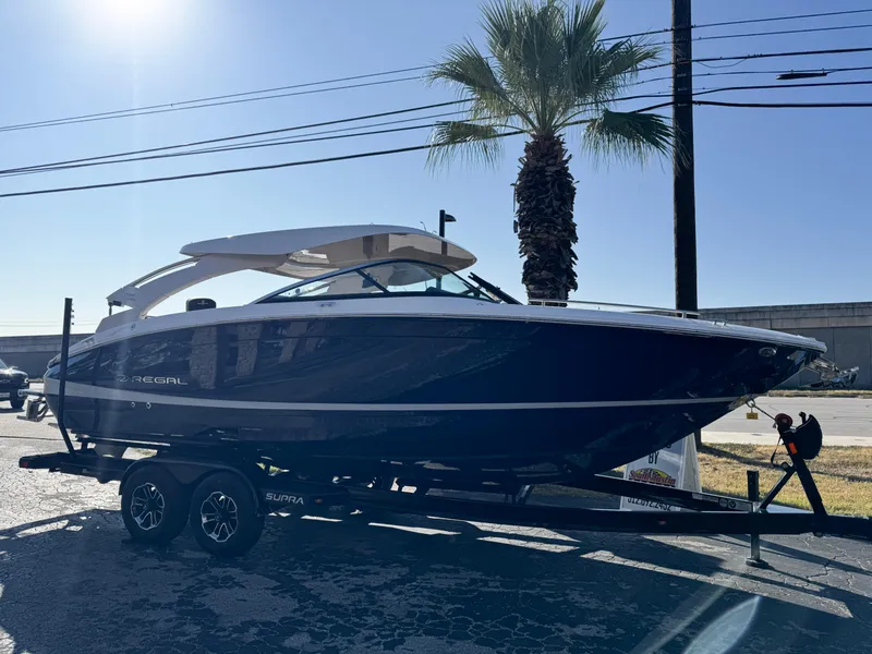 Slide: The Image of 2025 Regal LS6 boat on trailer, parked outdoors near palm tree. - 8