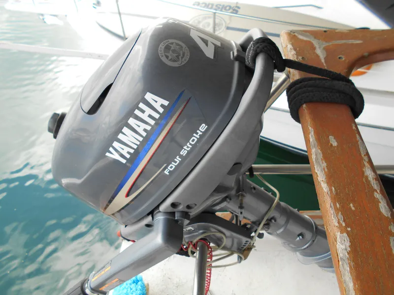 Slide: The Image of Yamaha four-stroke outboard motor on a 1977 Davis 42' boat, docked by the water. - 21