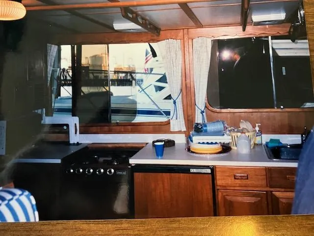 Slide: The Image of Interior of a 1977 Davis 42' boat kitchen with wooden cabinets and appliances. - 36