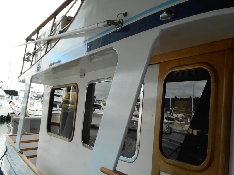 Slide: The Image of 1977 Davis 42' boat docked, featuring wooden accents and large windows. - 4