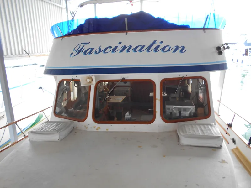 Slide: The Image of 1977 Davis 42' boat named "Fascination" docked in a covered marina. - 8