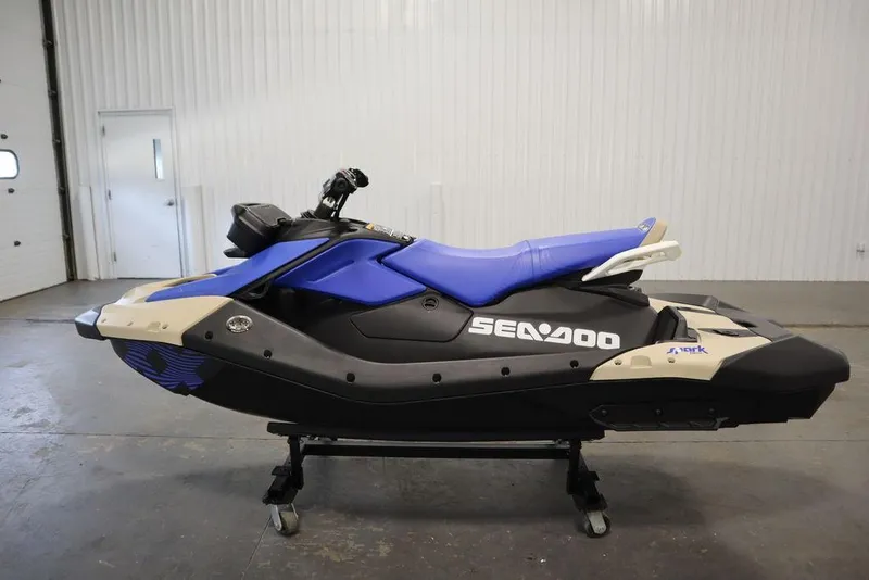 Slide: The Image of 2025 Sea-Doo Spark Trixx jet ski, blue and black, in a garage setting. - 6