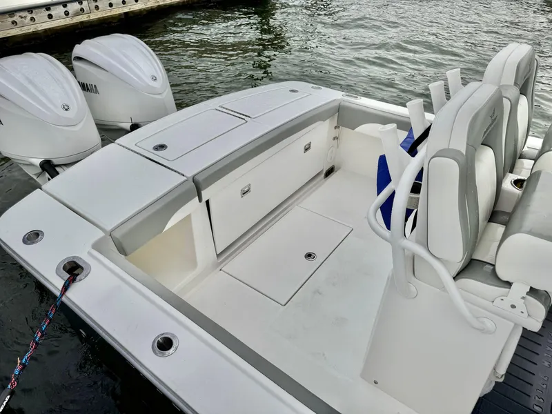 Slide: The Image of 2023 Regulator 28 boat with dual engines, spacious seating, and storage, docked by the water. - 15