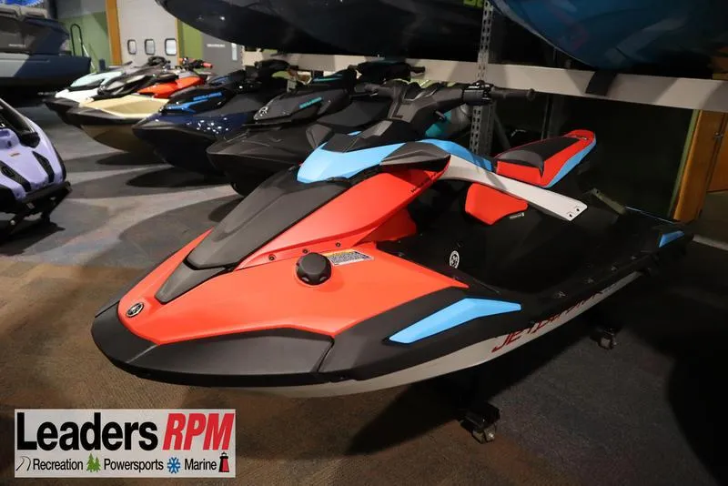 The Image of 2025 Yamaha WaveRunner JetBlaster DLX 3-Up in showroom, vibrant red and blue design. - 1