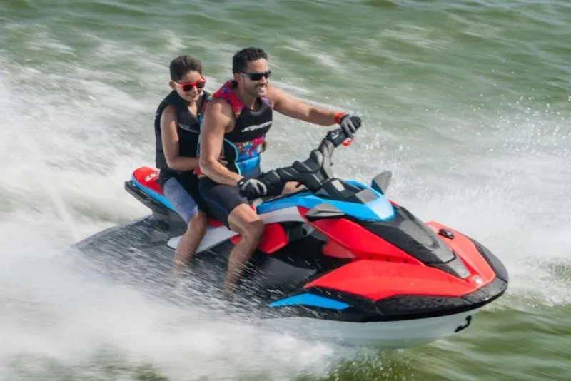 Slide: The Image of 2025 Yamaha WaveRunner JetBlaster DLX 3-Up speeding on water with two riders. - 20