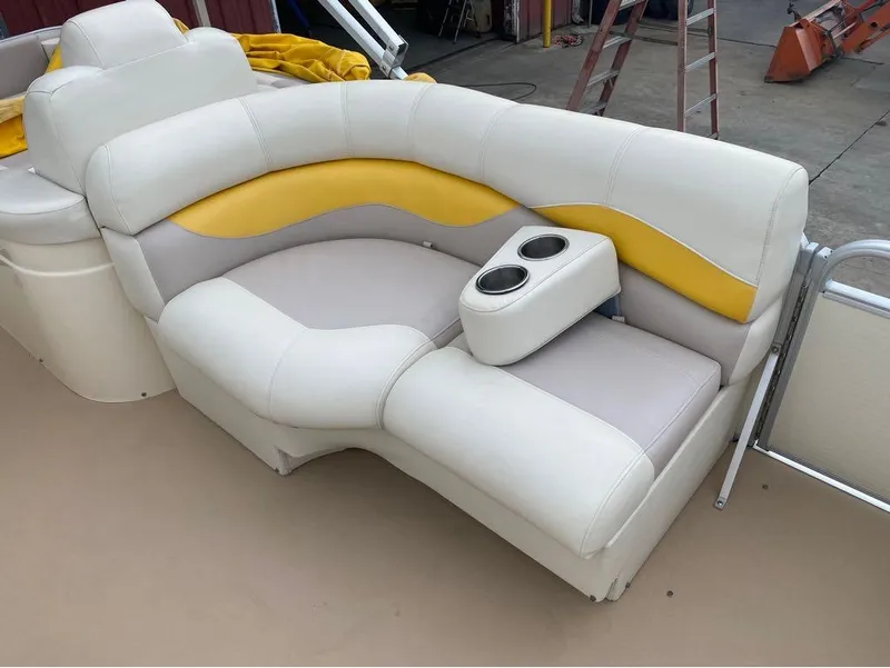 Slide: The Image of Godfrey AP 240 2012 boat seating with cup holders, featuring white and yellow upholstery. - 11