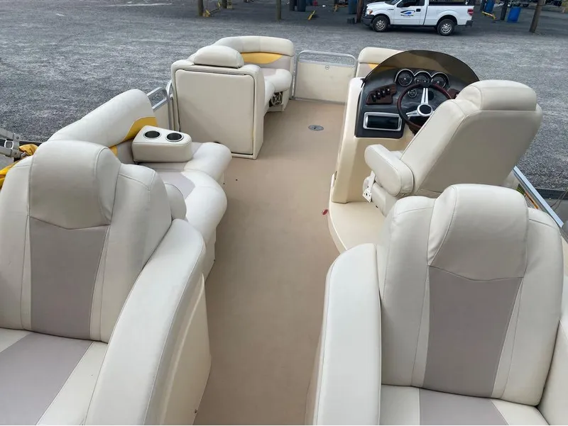 Slide: The Image of Interior of 2012 Godfrey AP 240 boat with beige seating and steering console. - 4